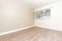 An empty bedroom featuring a long window along the back wall, allowing plenty of natural light to brighten the space
