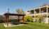 A picturesque patio showcasing a gazebo and picnic table, positioned in front of a lovely house.