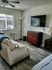 A well-organized living room with a couch and a television, offering a serene space for leisure and enjoyment.