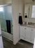 A clean bathroom featuring a shower, sink, and toilet, designed for functionality and comfort.