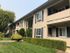 The apartment complex located at the intersection, featuring a lush green lawn in the foreground.