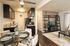 A cozy living room and dining area in a two-bedroom apartment, featuring modern furnishings and warm lighting.