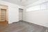An empty space characterized by white walls and warm wooden flooring, offering a minimalist and serene environment.