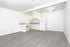 A minimalist kitchen with white walls and wooden floors, exuding a sense of tranquility and spaciousness.