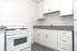 A stylish kitchen with pristine white cabinets and a functional stove, highlighting a fresh and organized culinary environment.