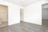 A vacant room characterized by white walls and natural wooden floors, providing a clean and open space.