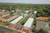 Bird's-eye view of a housing complex with several structures and designated parking areas visible.
