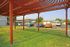 A spacious covered patio featuring parked cars in front, creating a welcoming outdoor space for gatherings.