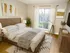 A modern bedroom with a wooden bed and white bedding, a flat-screen TV, a chest of drawers, abstract art, and a large window with vertical blinds.