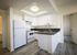 Contemporary kitchen with dark countertops and white cabinets and appliances