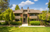 garden style exterior of community with blue skies, white clouds and vibrant green trees.