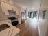 Kitchen with white granite counters looking towards living area