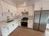 Kitchen with granite counters, white cabinetry, and stainless steel appliances