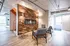 Modern lobby with wood-paneled accent wall, narrow fireplace, and stylish seating. Natural tones, bright lighting, and cozy ambiance.