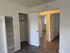 A vacant room with a single door and a radiator positioned against the wall.