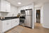 white kitchen with dark countertops and stainless steel appliances