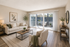 A minimalist living room with hardwood flooring and white walls, emphasizing a clean and open space.
