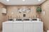 Inviting laundry room with modern washing machines, stylish wall art, and a charming green plant accent.