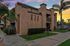 Charming apartment building with modern architecture, surrounded by lush greenery and a scenic sunset sky.