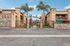 Charming gated apartment complex featuring lush palm trees and inviting entryway.