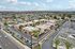 Aerial view of a modern apartment complex with lush palm trees, ample parking, and convenient access to nearby urban amenities.