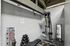 Chic home gym corner with modern weight machine, dumbbells, and a sleek mirror, perfect for fitness enthusiasts seeking convenience.