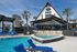 Inviting pool area with modern loungers and palm trees at Arcadia on the River.