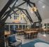 Spacious community hall with modern chandeliers, high wooden beams, and stylish seating area.