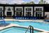 Inviting outdoor pool area with modern loungers and sleek architecture under a clear sky.