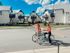 Peaceful neighborhood with modern white houses and two people enjoying a bike ride.