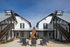Inviting courtyard with modern white townhouses, wooden staircases, and a centerpiece fire pit surrounded by seating.