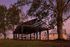 Stunning pavilion set amid trees with charming houses in the background during sunset.
