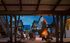 Charming courtyard with modern architecture and a warm fire pit surrounded by comfortable seating under a starry sky.