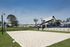 Outdoor beach volleyball court with a modern community center and green spaces.
