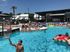 Lively apartment community pool with people enjoying sunbathing and swimming.
