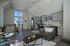 Elegant open-plan living room with modern kitchen, featuring gray cabinetry and large windows with abundant natural light.