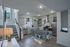 Modern kitchen with sleek gray cabinets, stainless steel appliances, and stylish dining area.