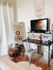 Inviting home workspace featuring a modern desk, cozy chair, large mirror, and decorative elements.