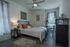 Inviting bedroom with stylish decor, featuring a comfortable bed, sleek ceiling fan, and elegant furnishings.
