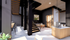 Modern open-concept living space with sleek black accents, elegant staircase, and dining area perfect for entertaining.