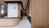 Luxurious modern hallway with elegant wood paneling, a sleek marble accent wall, and a stylish open staircase.