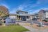 Inviting entrance of Thompson San Marcos with modern architecture, lush landscaping, and clear blue skies.