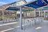 Chic outdoor seating area with stylish bar stools and string lights, perfect for sunny gatherings and relaxation.