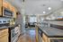 Contemporary kitchen and living space featuring sleek appliances, warm wooden cabinetry, and vibrant decor offering a cozy and inviting atmosphere.
