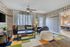 Charming living room with vintage wall decor, cozy seating area, colorful geometric rug, and plenty of natural light.