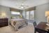 Bright and cozy bedroom with modern decor, featuring stylish blinds, a plush bed, and elegant lighting.