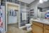 Modern bathroom featuring stylish plaid wallpaper, sleek vanity, and an open closet space for convenience.