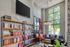 Chic living room with high ceilings, large bookshelf, and expansive windows offering abundant natural light.