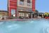 Elegant apartment exterior with a shimmering pool and stylish outdoor seating.