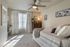 Cozy bedroom with soft natural light, featuring a stylish bed, elegant decor, and a modern ceiling fan.